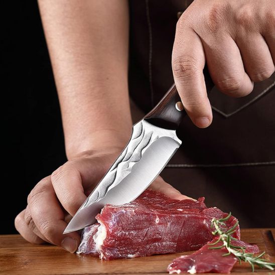 Couteau cuisine coupant un morceau de viande.