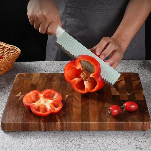 Planche à découper bois acacia avec poivron rouge frais
